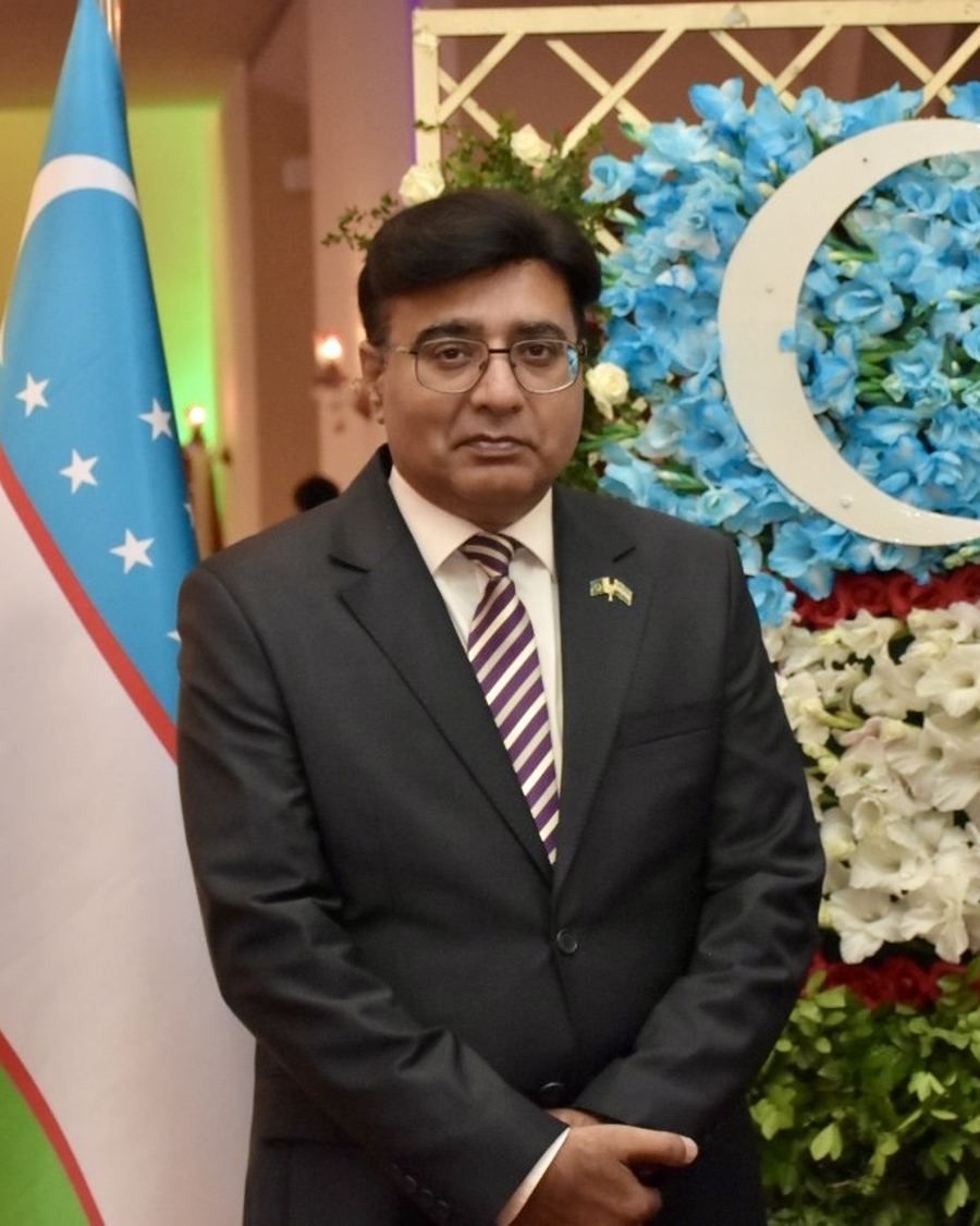 Hamid Mahmood, Brand Ambassador of Uzbekistan Tourism in Pakistan, beside the flag of Uzbekistan