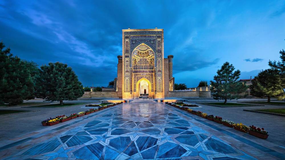 A tiled portal of a madrasah lit at blue hour in Uzbekistan